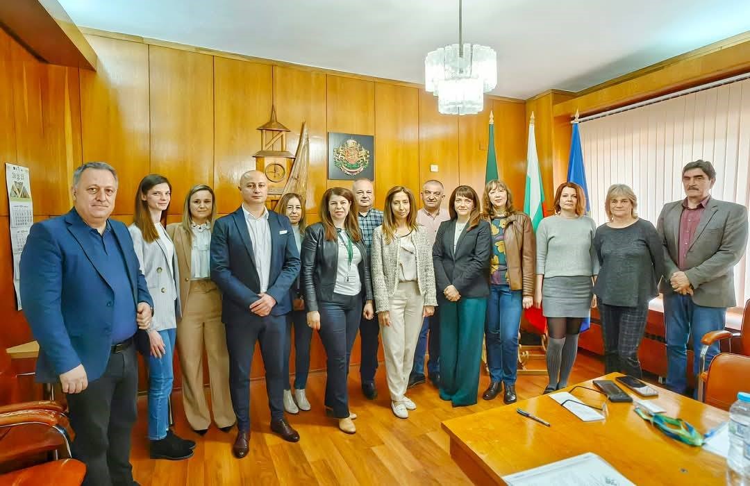 Група професионалисти в зала с дървени стени.