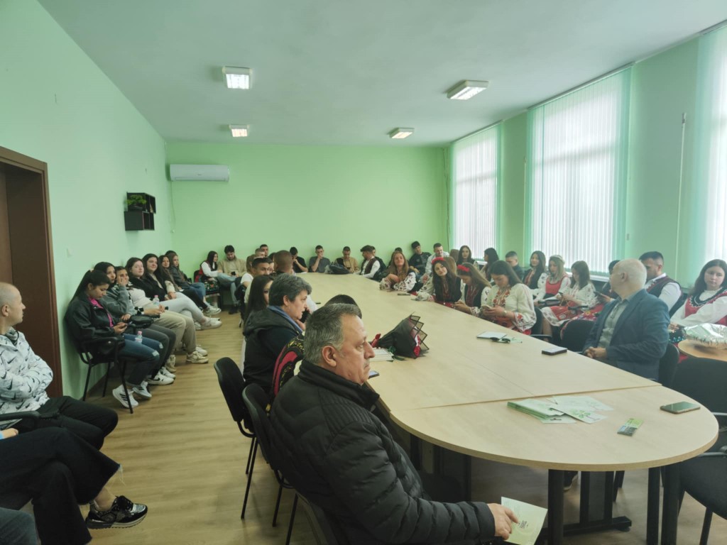 Среща с много участници в заседателна зала.