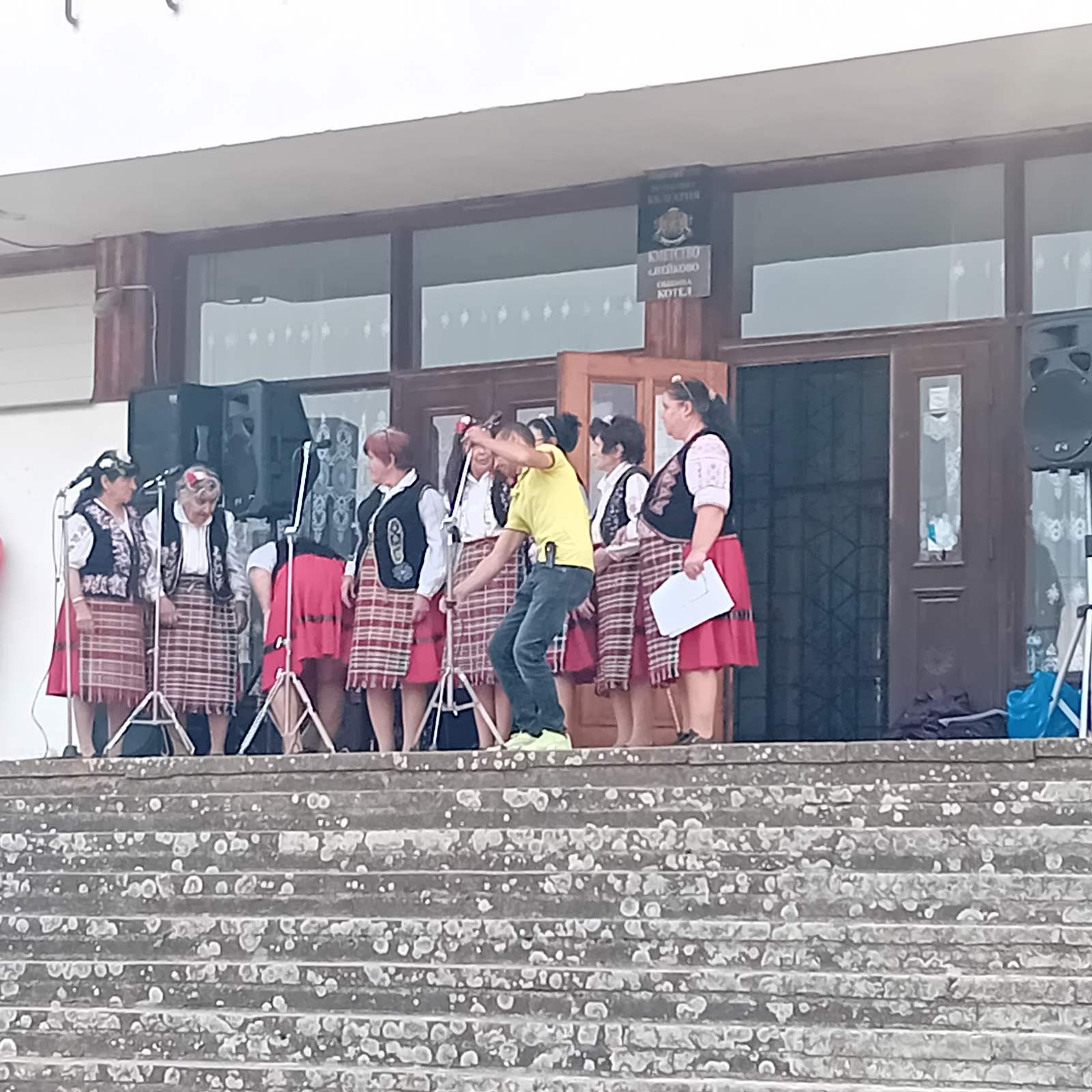 Младежи в народни носии на стъпала.
