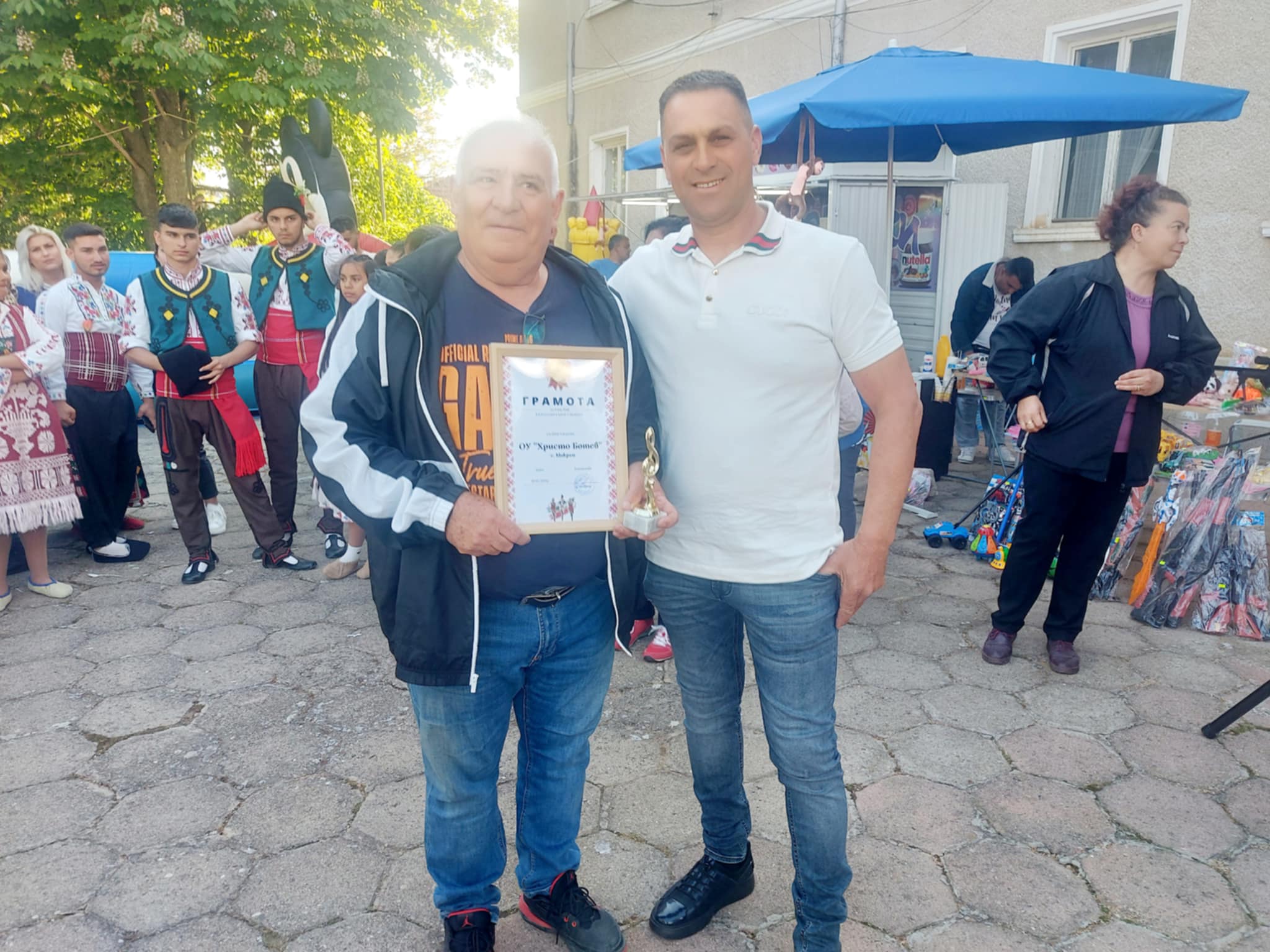 Двама мъже държат сертификат на събитие.