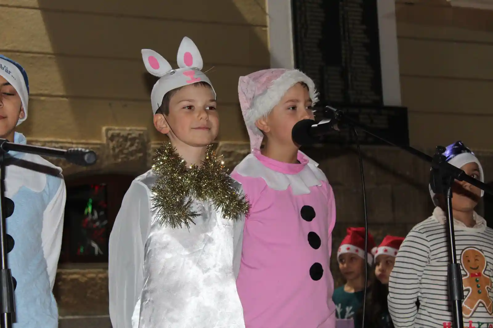 Деца в коледни костюми на сцена.