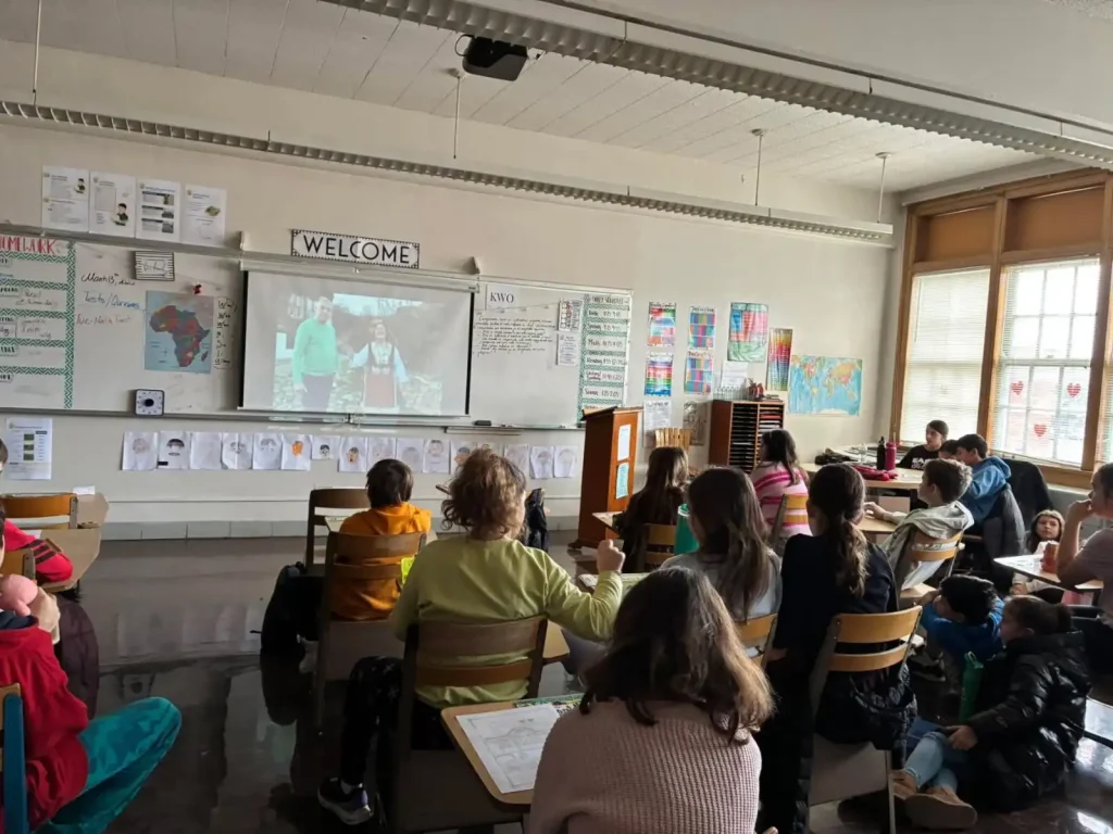 A classroom scene with students watching a presentation on a screen, engaged in a discussion about Bulgarian traditions.