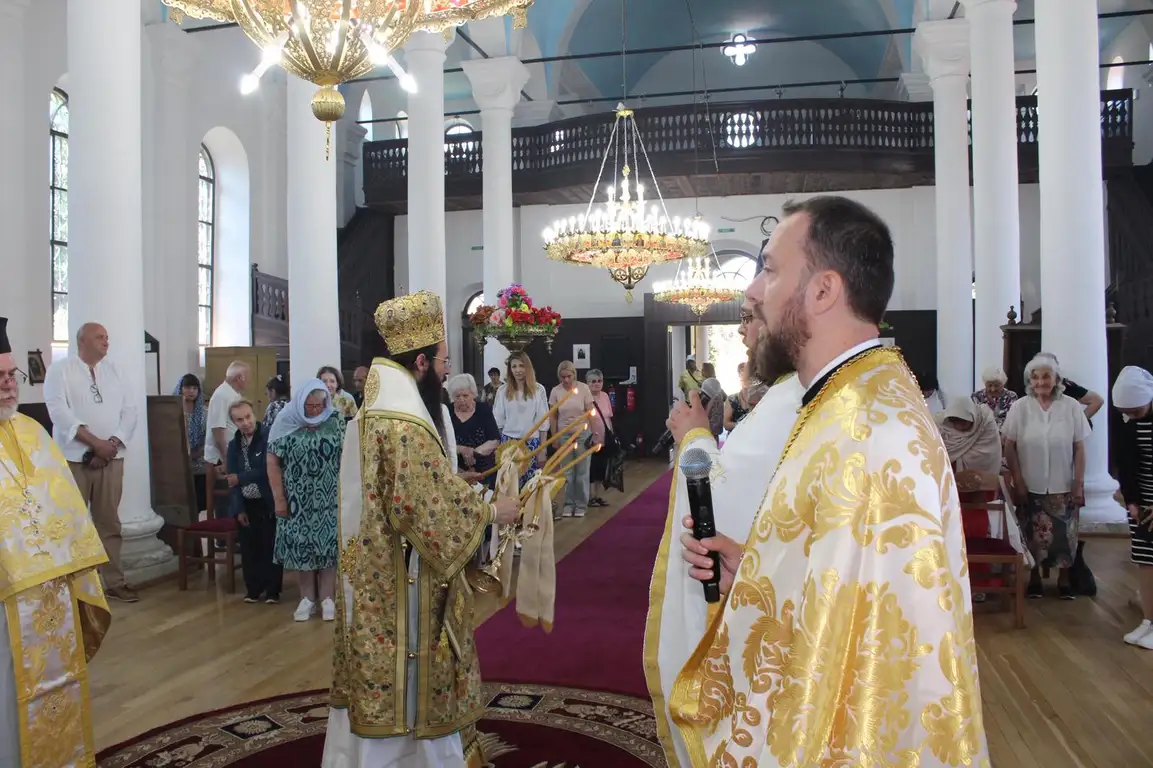 Служба в църква с духовници и миряни, светла и тържествена обстановка.