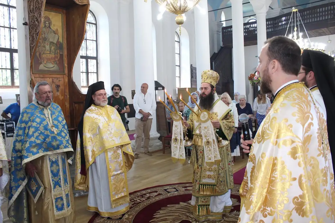 Църковна церемония с духовници в традиционни одежди и свещи в ръка, богослужене в християнски храм.