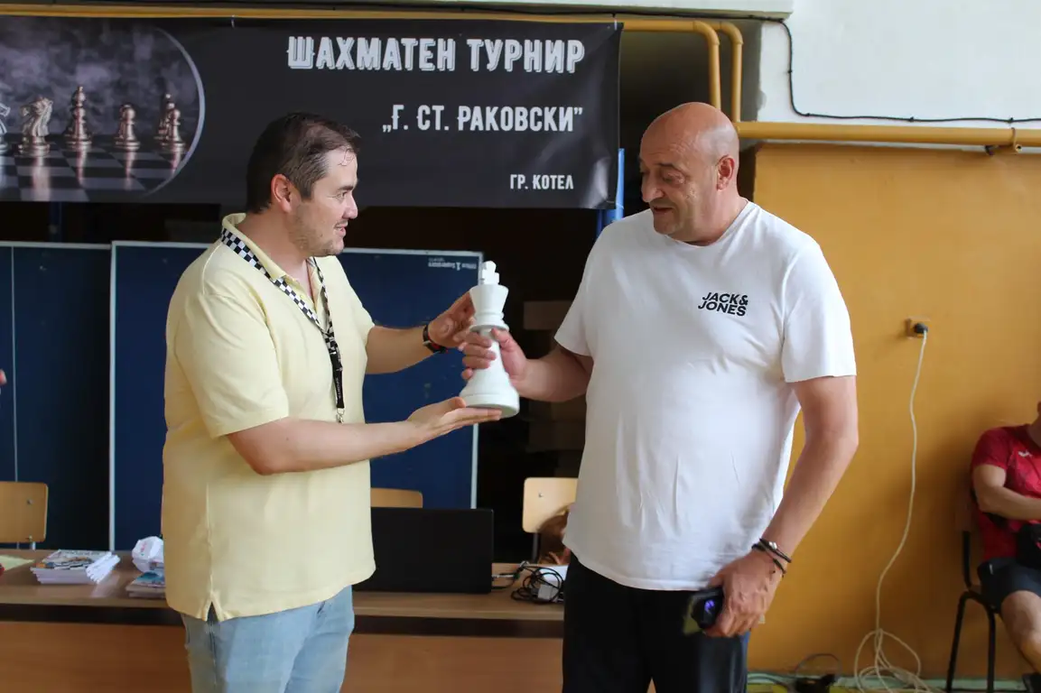 Шахматен турнир в Котел. Играч предава статуетка на победителя.
