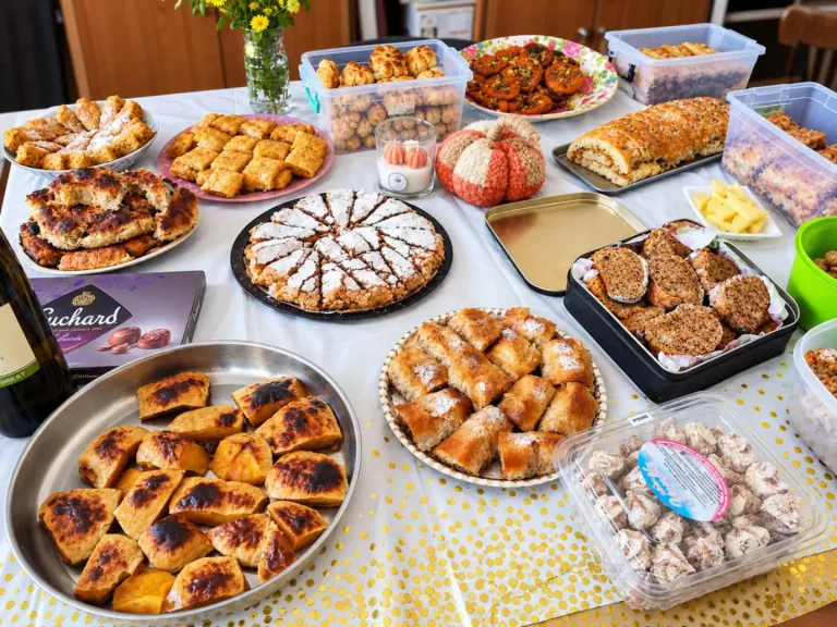 Разнообразие от вкусни сладкиши и десерти на празнична маса, украсена с жълти конфети.