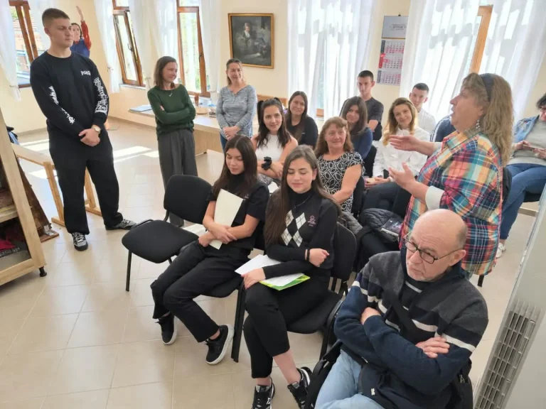 Събрание на хора в уютна стая, обсъждащи важна тема и взаимодействие между поколения.